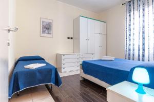 een slaapkamer met 2 bedden en een dressoir bij Appartamento Tony in Sperlonga