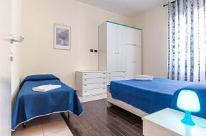 een slaapkamer met twee bedden en een ladekast bij Appartamento Tony in Sperlonga