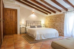 a bedroom with a bed and a stone wall at Hotel Can Simo in Alcudia