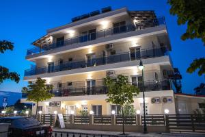 a white building with balconies and a car parked in front at Olympic Coast in Olympic Beach