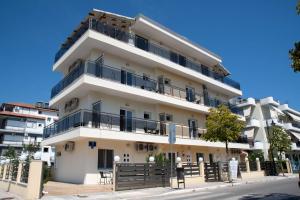 a tall white building with balconies on a street at Olympic Coast in Olympic Beach