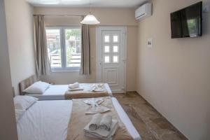 a bedroom with two beds with towels and a window at Olympic Coast in Olympic Beach