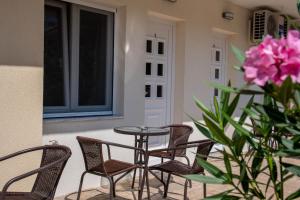 a patio with chairs and a table and pink flowers at Olympic Coast in Olympic Beach