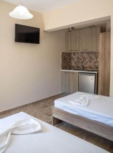 two beds in a room with a tv on the wall at Olympic Coast in Olympic Beach