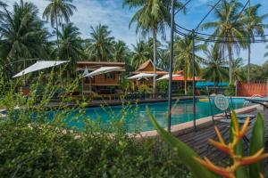 a resort swimming pool with palm trees in the background at The Ford SunSet Beach Resort in Wok Tum