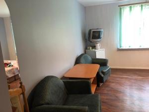 a room with two chairs and a table and a tv at Druspolis in Druskininkai