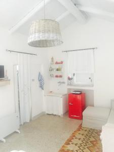 uma cozinha com paredes brancas e um frigorífico vermelho em LOFRUs PLACE em Pomarico