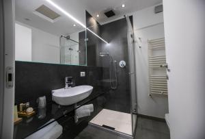 een zwart-witte badkamer met een wastafel en een douche bij Suite Quaroni in Palermo