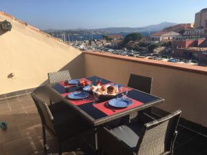 a table with food on top of a balcony at Penthouse Cala Gavetta in La Maddalena