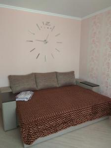 タンボフにあるквартираのベッドルーム1室(ベッド1台、壁掛け時計付)