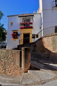 un edificio blanco con macetas en la ventana en Ronda, en Ronda