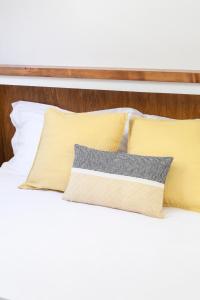 - un lit avec des draps blancs et des oreillers jaunes dans l'établissement Gianburrasca, à Florence