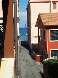 拉伊圭利亞的住宿－Appartamento "Un Bacio sul Mare"，两座建筑之间的小巷,以海洋为背景