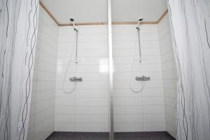 a shower in a bathroom with white tiles at Sogndal Bed & Breakfast in Sogndal +27 photos