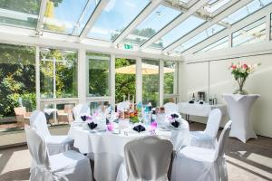 a room with white tables and chairs and windows at ACHAT Hotel Bad Dürkheim in Bad Dürkheim +45 photos