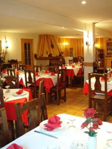 ein Restaurant mit Tischen und Stühlen mit rotem Tischtuch in der Unterkunft Hotel Tres Arcos in San Lorenzo de El Escorial