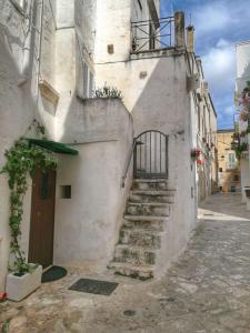 ein Steingebäude mit einer Treppe, die zu einer Tür führt in der Unterkunft L' Edera in Fasano