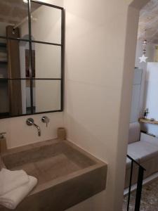 ein Badezimmer mit einer Badewanne, einem Spiegel und einem Stuhl in der Unterkunft L' Edera in Fasano