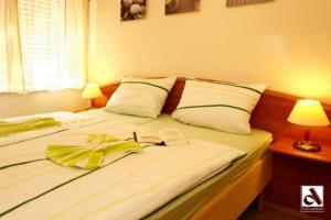 a bed with white sheets and a yellow towel on it at Haus Seeschwalbe in Ostseebad Karlshagen
