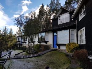 a black and white house with a yard at The Patagonian Lodge in Coihaique