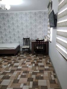 a bedroom with a bed and a table and chairs at Datka Guest House in Naryn