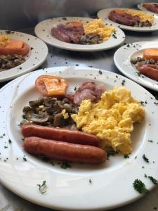 a plate of food with sausage eggs and mushrooms at Water on Waldrift Guesthouse in Vereeniging