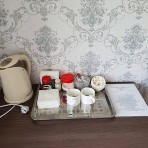 a tray with dishes and cups on a table at Datka Guest House in Naryn