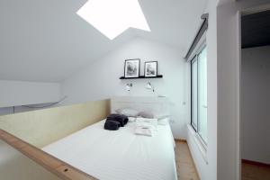 a bedroom with a white bed in a room with a window at Dubocage45Citycenter in Faro