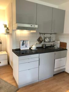 cocina con armarios blancos y encimera negra en Ferienwohnung Kraft, en Clausthal-Zellerfeld