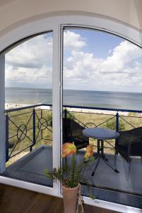 - un balcon avec une table et une vue sur l'océan dans l'établissement Haus auf der Duene Fewo Ostseeblick, à Trassenheide