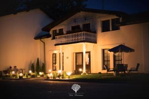 a large white house with a balcony at night at Pod Platanem Gliwice in Gliwice