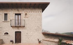 un edificio de piedra con un balcón en un lateral. en Il Vecchio Frantoio, en Grottaminarda