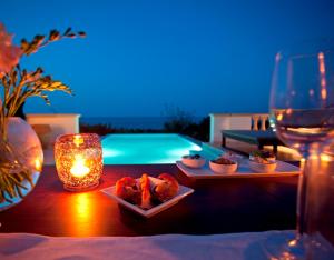 a table with a plate of food and a glass of wine at Anassa in Polis Chrysochous