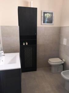 een badkamer met een witte wastafel en een toilet bij La mia Casa in Napels