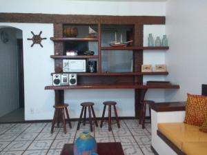 un bar en la esquina de una sala de estar con taburetes en GERIBÁ APART HOTEL APARTAMENTO 109, en Búzios