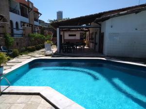 uma piscina no quintal de uma casa em Apartamentos Ponta do Sol em Natal