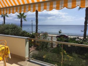 a balcony with a view of the ocean at Le Zagare apartments in SantʼAlessio Siculo