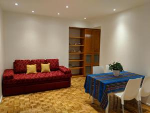 uma sala de estar com um sofá vermelho e uma mesa em Apartamento Edificio Crucero em Buenos Aires