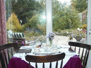 une table avec un chiffon de table violet et une fenêtre dans l'établissement Compton House, à Ashbourne
