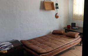 un sofá marrón sentado en una habitación con una mesa en Casa Maria Luisa, en San Miguel de Abona