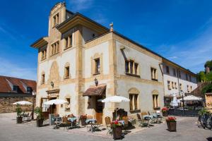 un bâtiment avec des tables et des chaises devant lui dans l'établissement Le Domaine de Rouffach, à Rouffach