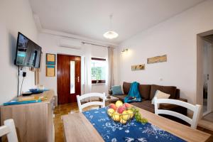 sala de estar con sofá y mesa con un bol de fruta en Apartment Mediteraneo, en Opatija