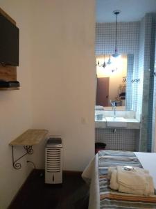 a bathroom with a bed and a sink in a room at Pousada da Bia in Tiradentes