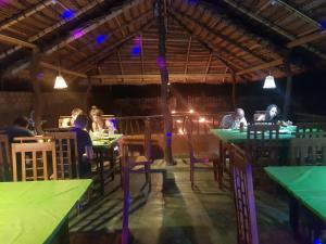 a group of people sitting at tables in a restaurant at Kirinda Beach Front Hotel in Kirinda