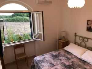 1 dormitorio con cama y ventana en Agriturismo "Lo zafferano", en Aprilia