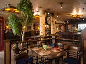 un restaurant avec des tables, des chaises et une horloge dans l'établissement Posthaus Hotel Residenz, à Kronberg im Taunus