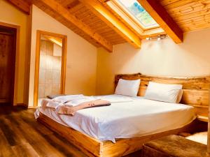 a bedroom with a large bed with a wooden headboard at Bujtina Polia in Theth