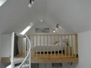 ein Kinderbett in einem Zimmer mit weißer Decke in der Unterkunft Chez Jeannette in Plouguerneau