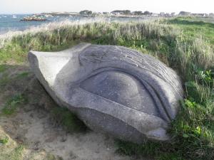 ein großer Felsen im Gras neben dem Wasser in der Unterkunft Chez Jeannette in Plouguerneau