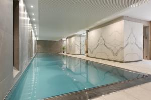 a swimming pool with blue water in a building at Martin's Louvain-la-Neuve in Louvain-la-Neuve